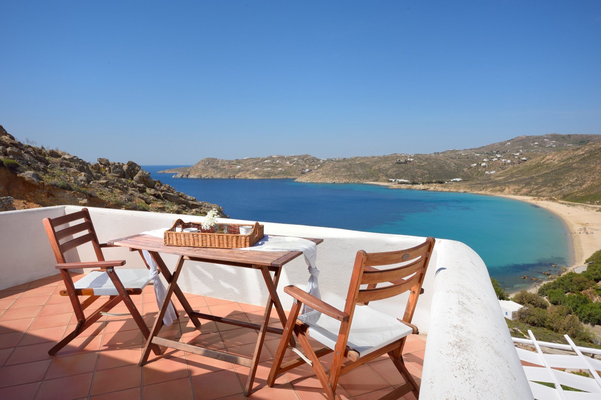 Balcony table for two above the curve of Elia Bay