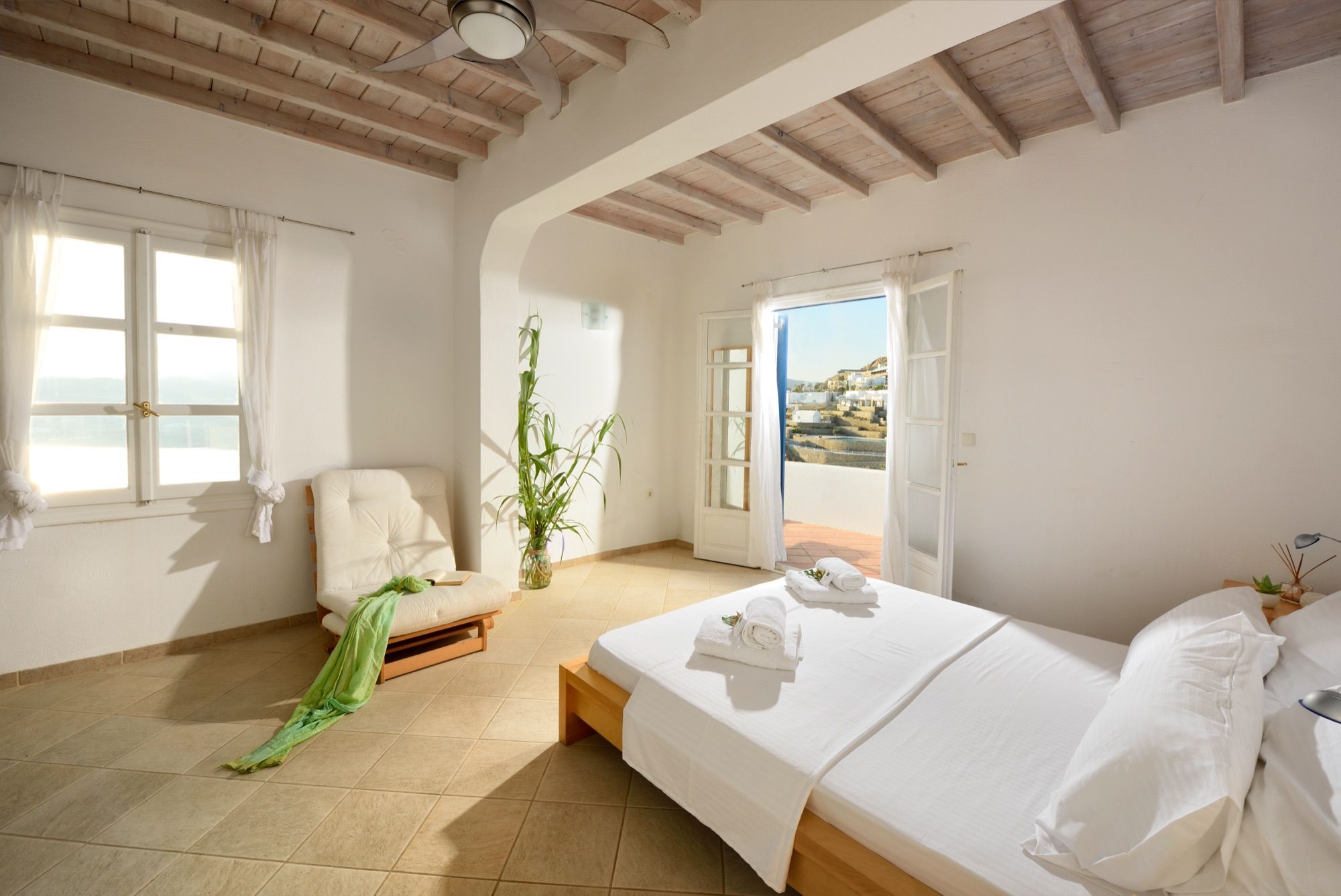 Bright bedroom with a double bed under a beamed ceiling