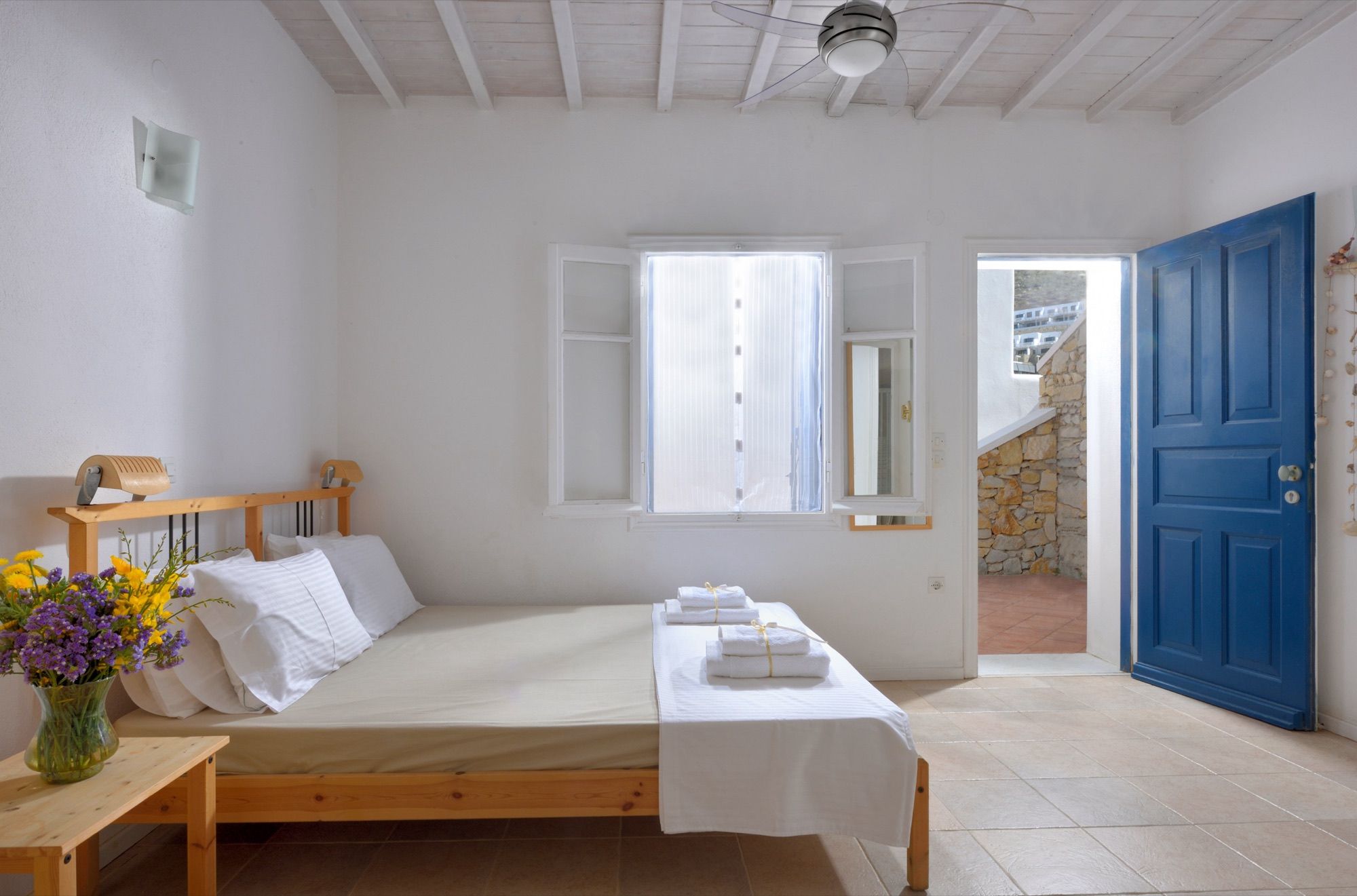 Bedroom with a double bed and a blue door opening directly outside