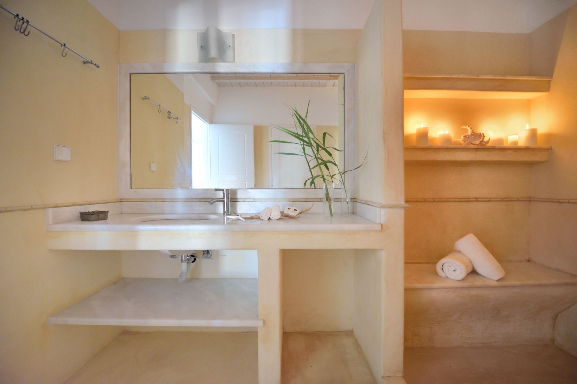 Bathroom with a stone basin and candlelit niches