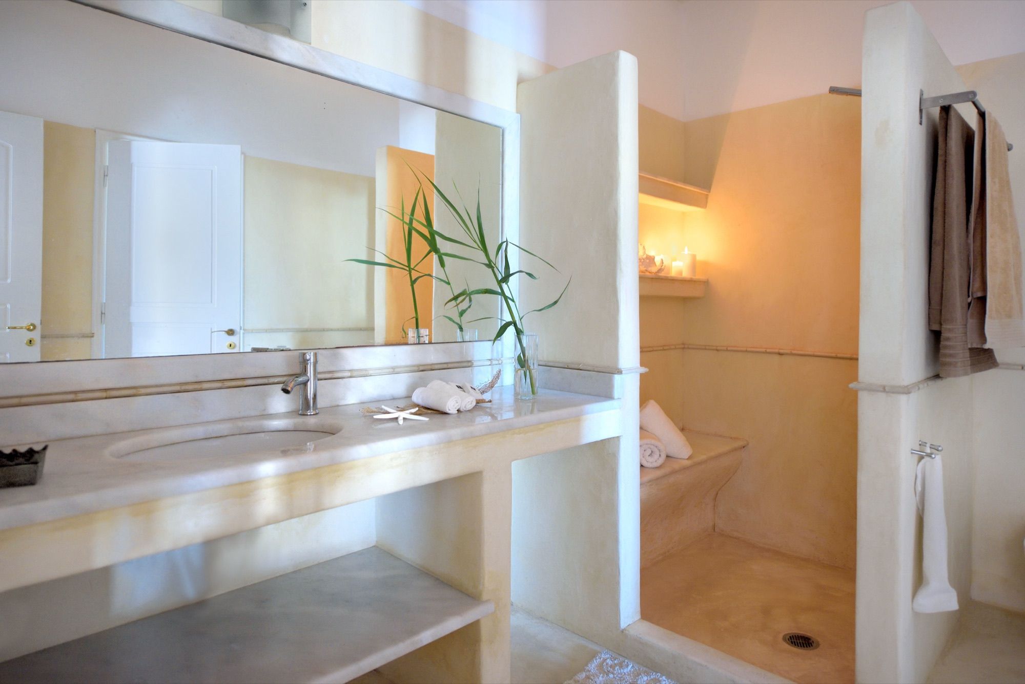 Bathroom with a built-in stone vanity and a walk-in shower with a lit niche