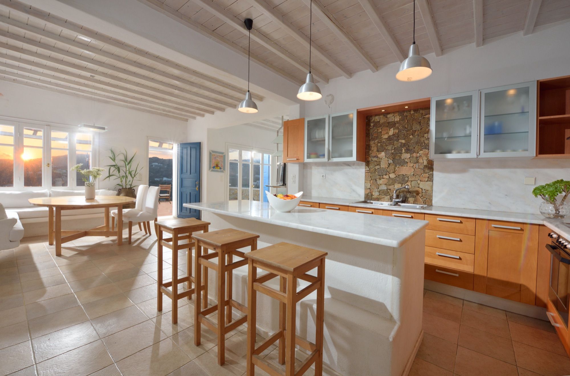 Kitchen with a breakfast bar, wooden cabinets and a stone feature wall