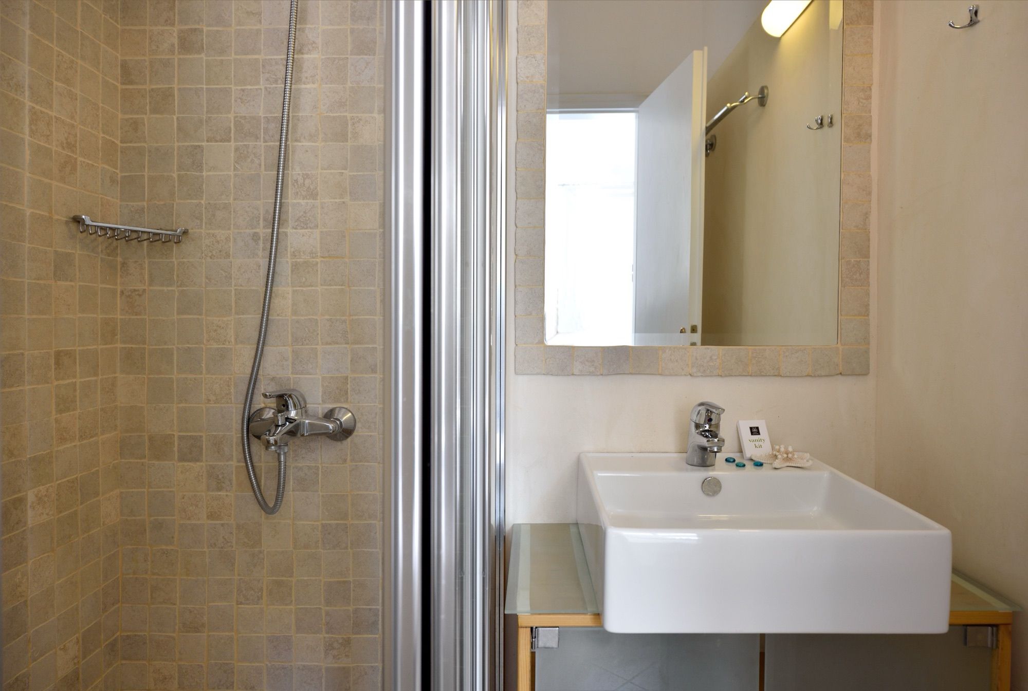 Bathroom with a shower, tiled walls and a white basin