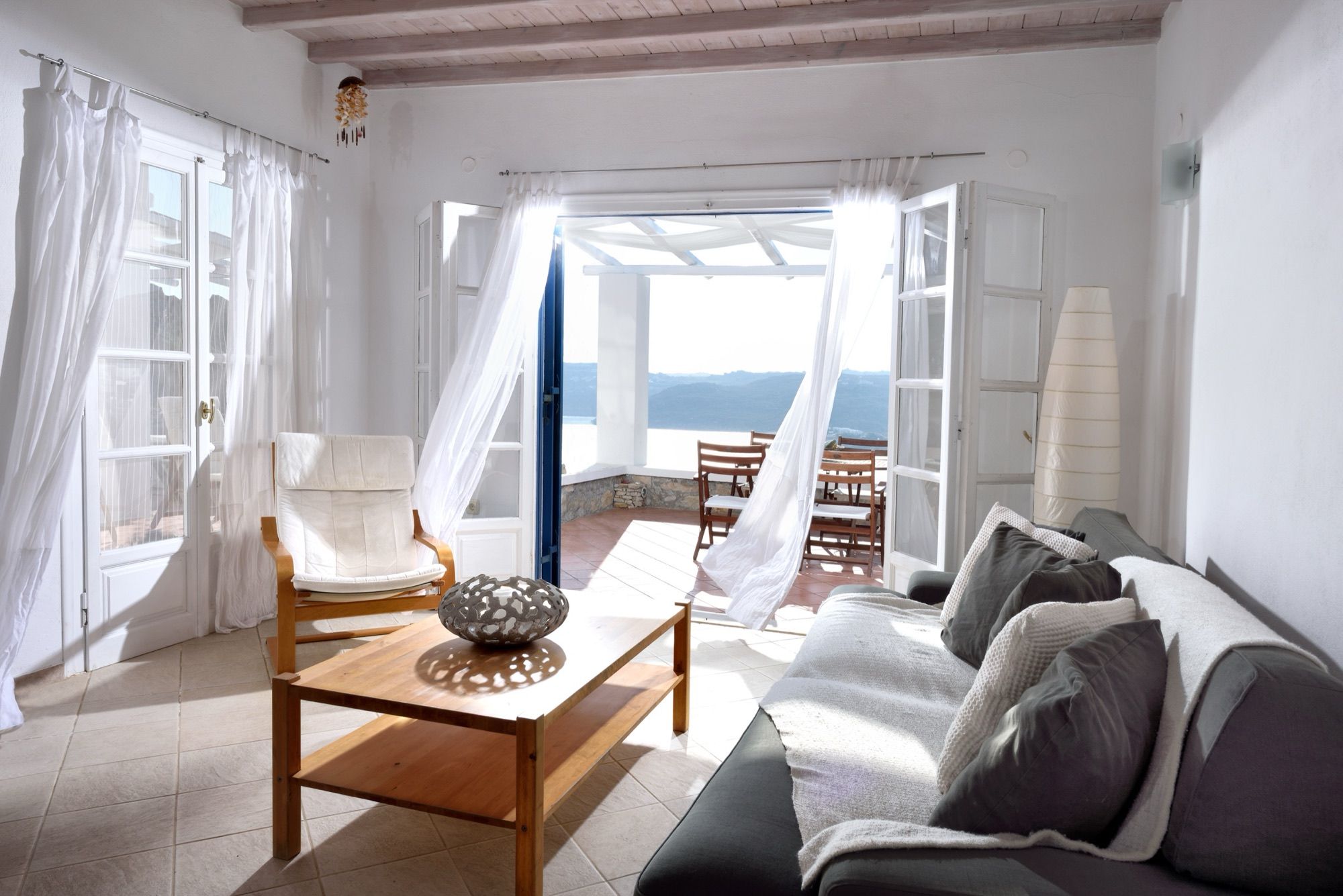 Living room with sofas and French doors open to the terrace and the sea
